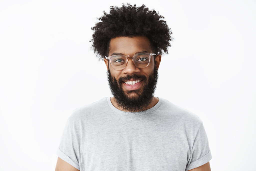 A black man with glasses and a beard on a white background.