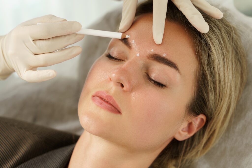 A woman getting her eyebrows injected with a needle.